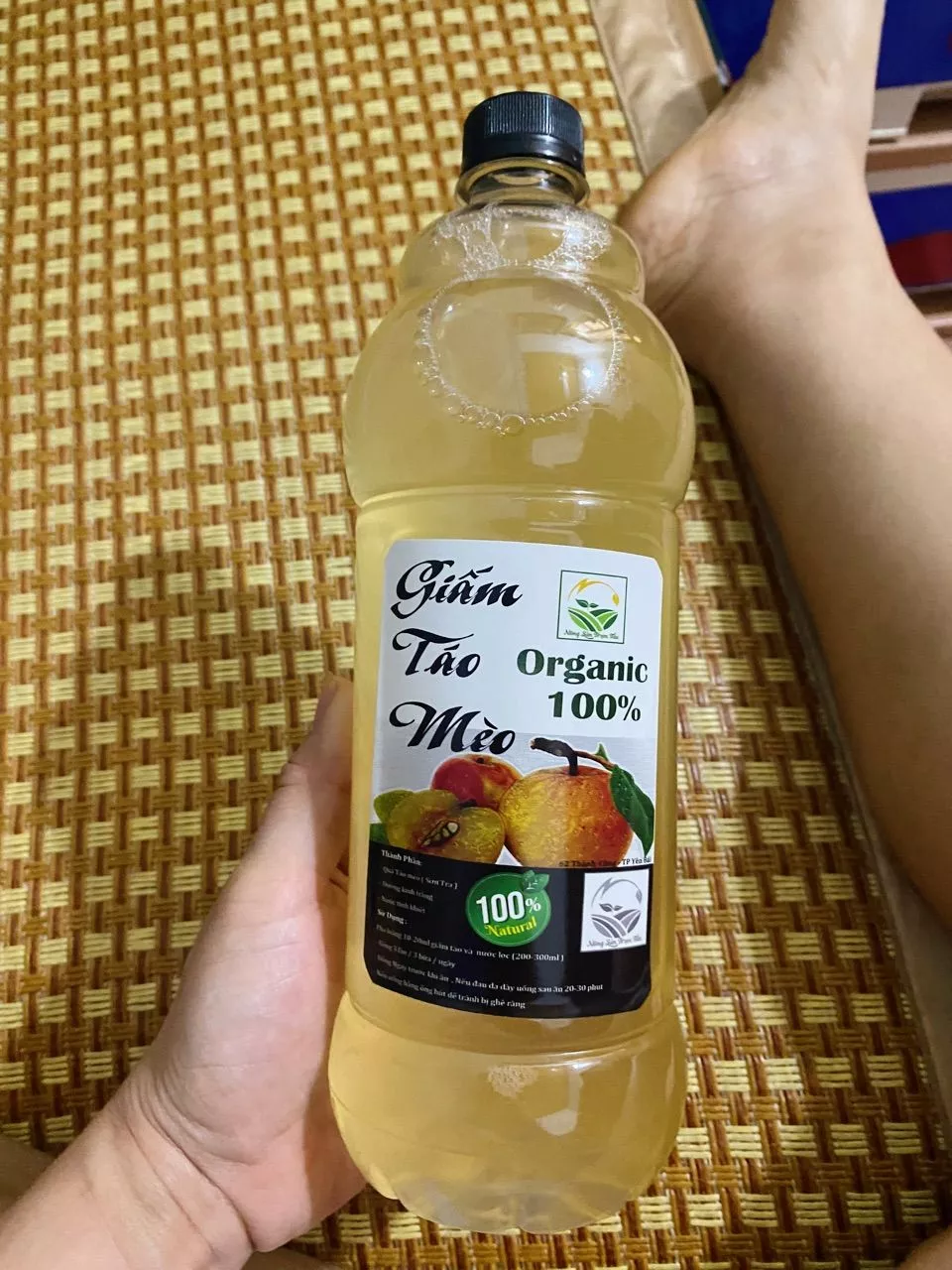 Khách cầm chai giấm táo mèo